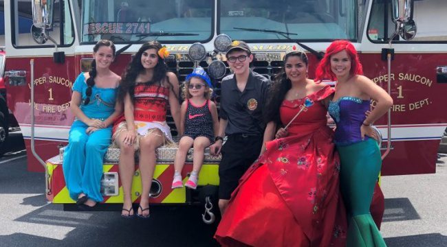 People in costumes posing in front of fire truck