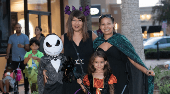 Family posing for photo wearing halloween costumes