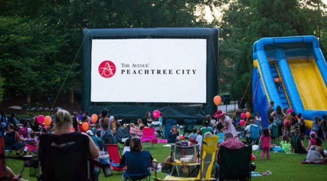 People outdoors watching large screen