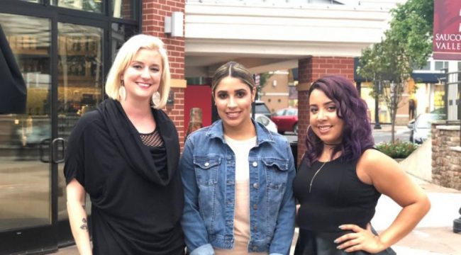 Three woman posing for photo outside of store fronts