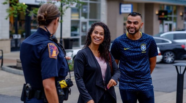 Police officer talking to two smiling people