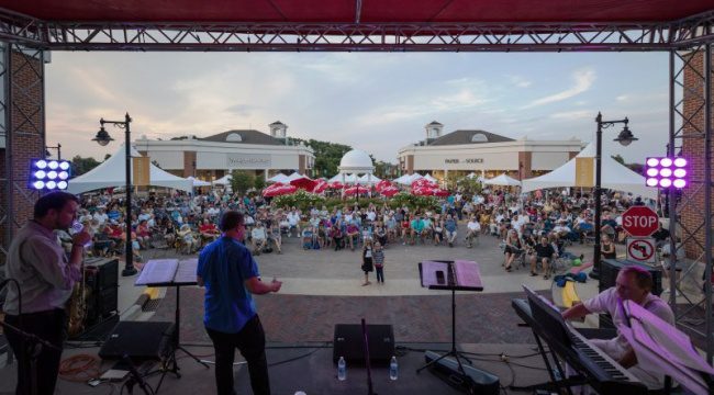 Musicians performing on stage with crowd in front