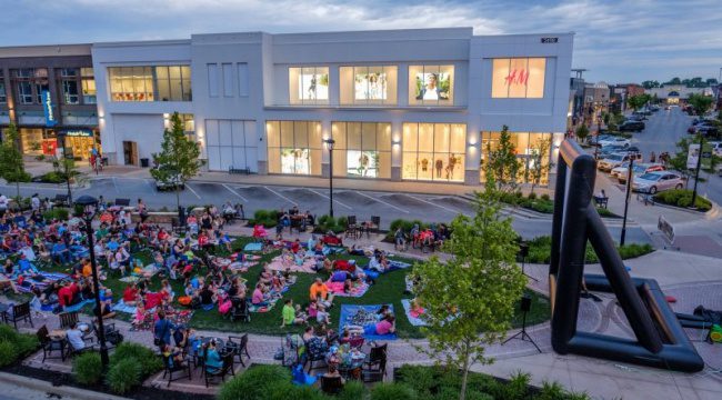 People outdoors watching large screen