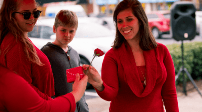 Young women being handed a rose