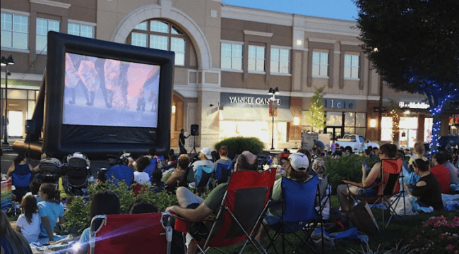 People sitting on chairs and watching outdoors movie