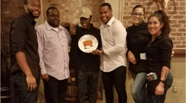 Group of young people holding dish and posing for photo